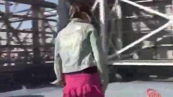 Girl in a skirt poops on the sidewalk